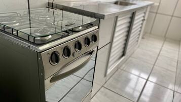 Appartement | Privékeuken | Een koelkast, een magnetron, een blender, kookgerei, borden en bestek