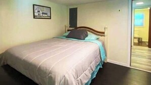 A bedroom with a bed, a headboard, a door, and a window. - Cozy Country Home for all ATV Riders! Direct Access to Tackett and Royal Blue! (LaFollette)