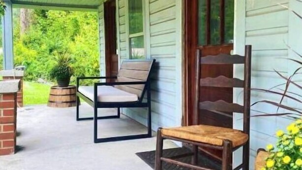 A covered porch with a bench and a chair, a small table, and a potted plant. - Cozy Country Home for all ATV Riders! Direct Access to Tackett and Royal Blue! (LaFollette)
