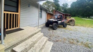 A house with a gravel driveway and a vehicle parked outside. - Cozy Country Home for all ATV Riders! Direct Access to Tackett and Royal Blue! (LaFollette)