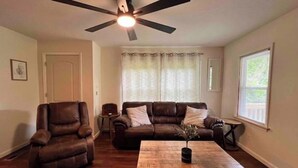 A living room with a brown leather sofa, a recliner, a wooden coffee table, and a ceiling fan. - Cozy Country Home for all ATV Riders! Direct Access to Tackett and Royal Blue! (LaFollette)