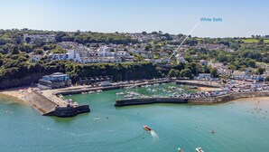 An aerial view of a coastal town with a marina, boats, and a white sailboat labeled "White Sails". - White Sails - Beach and Harbour Views (Saundersfoot)