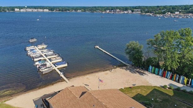 Ein Yachthafen mit vertäuten Booten, ein Sandstrand und eine Fahnenmast.