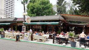 An outdoor cafe with outdoor seating and a covered area. - Billy's 2 bed apartment for Rent at Sun Village Complex (Слънчев бряг)