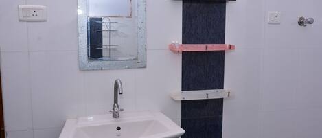 A bathroom with a white sink, a mirror, and a towel rack.