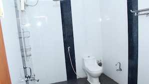 Une petite salle de bain avec des toilettes, une douche et un lavabo.