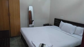 Une chambre à coucher avec un lit, une armoire en bois et un miroir au mur.