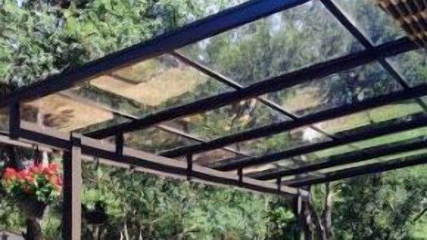 A covered patio area with a stone floor, outdoor furniture, and potted plants. - South Austin gem - Kickback and relax! (Manchaca)