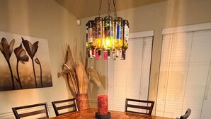 A dining room with a wooden table, six chairs, a central candle, and a hanging light fixture. - South Austin gem - Kickback and relax! (Manchaca)