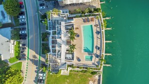 An aerial view of a hotel with a swimming pool, parking area, and a view of the sea. - Stunning 2BR 2BA  Bay Harbour with Pool (Bay Harbor Islands)
