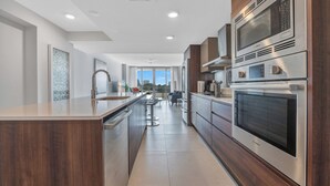 A modern kitchen with a central island, built-in appliances, and a view to the outdoors. - Stunning 2BR 2BA  Bay Harbour with Pool (Bay Harbor Islands)