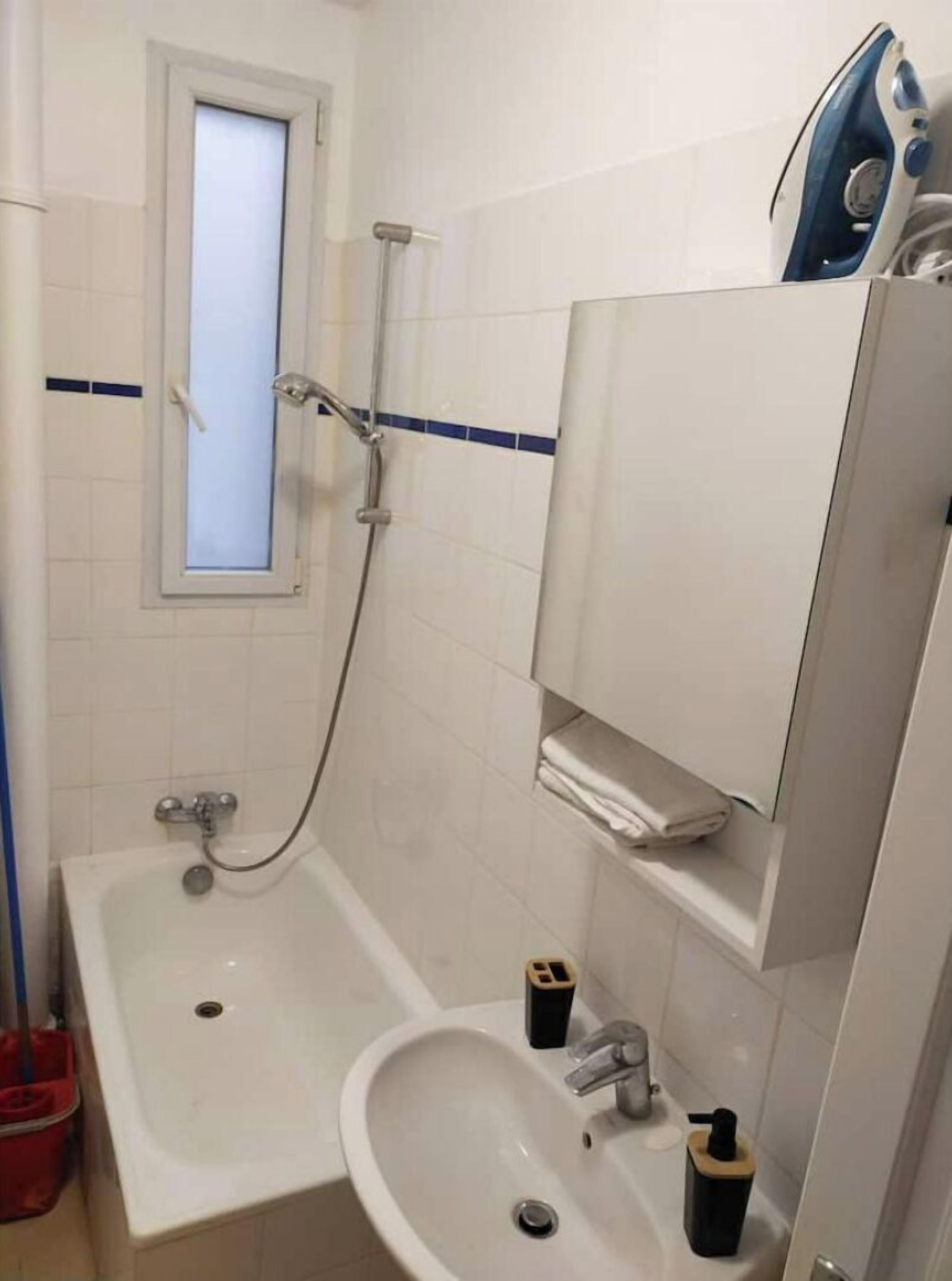 Une salle de bain avec une baignoire, un lavabo, un miroir et une douche.