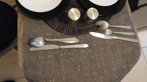 A dining table with two white plates, a black plate, and a decorative centerpiece. - joseph appartment  (Paris)