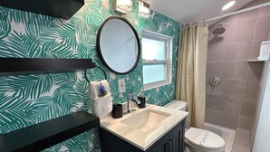 Un baño con lavamanos, espejo e inodoro.