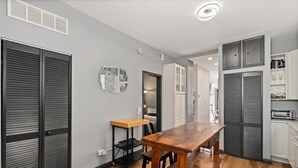 A modern kitchen with grey cabinets, a wooden table, and a built-in oven. - REMODELED Splendid Flat in Bucktown +Back Porch, Ranked GUEST FAVORITE! Pets OK! (Chicago)