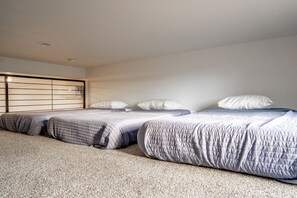 A bedroom with three beds, a headboard, and a carpeted floor. - Capitol Casita - 2BD+loft+2BA and rooftop deck (Wayne County)