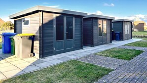 Een rij moderne, donkere gebouwen met grote ramen en een plat dak, waarschijnlijk woon- of kantoorgebouwen.