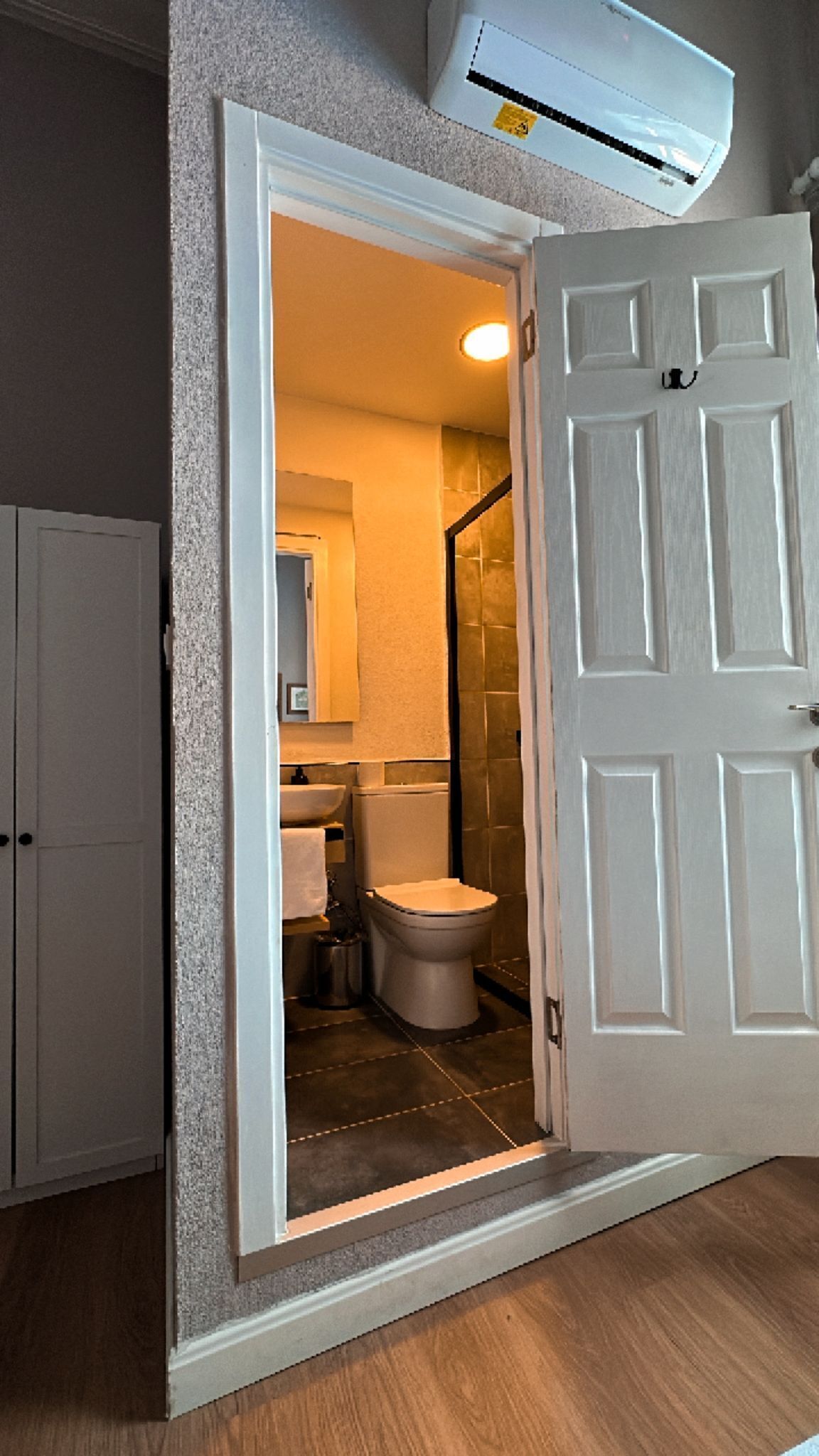 A bathroom with a toilet, sink, and mirror.