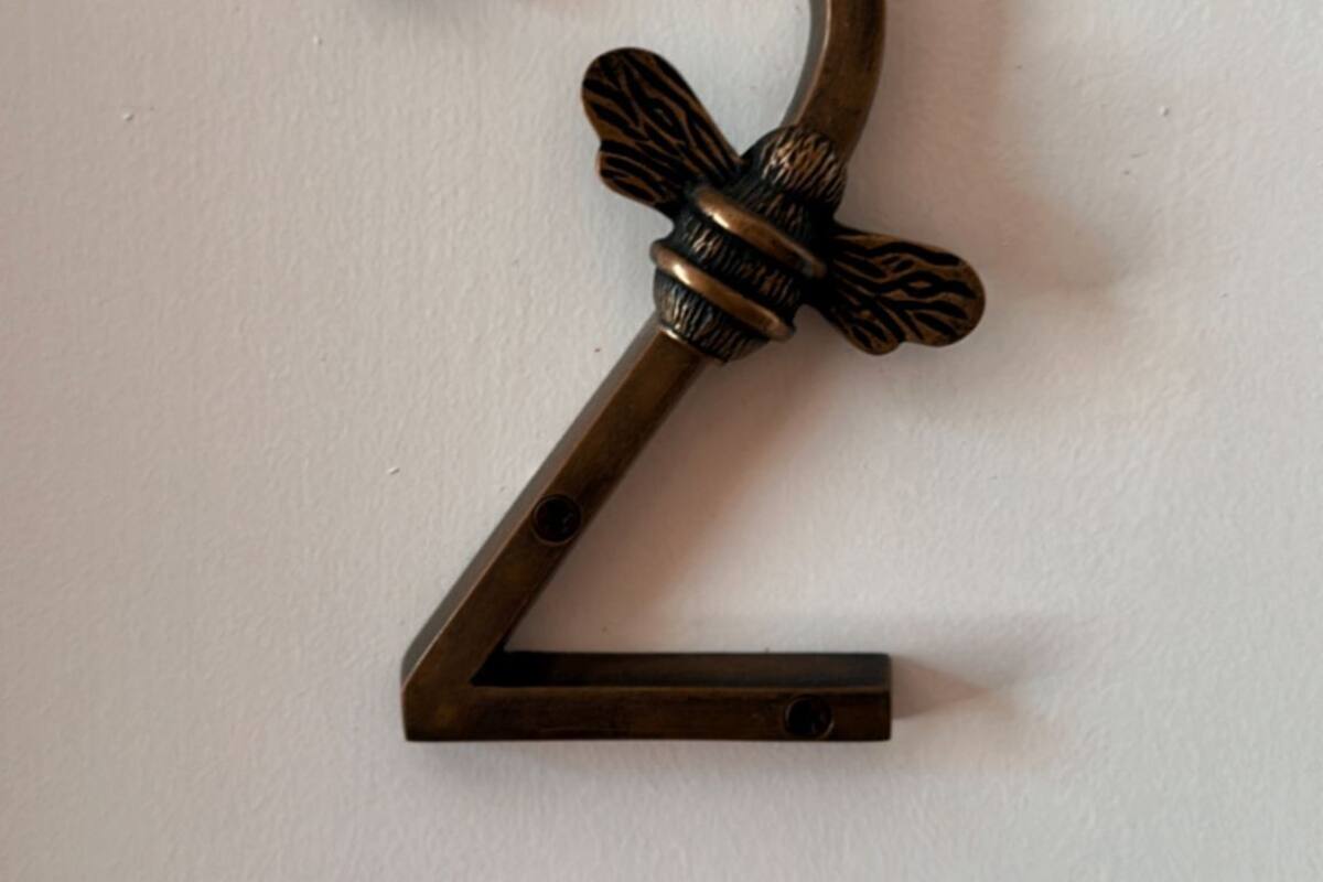 Una señal de metal decorativa con el número 2 y un lazo.