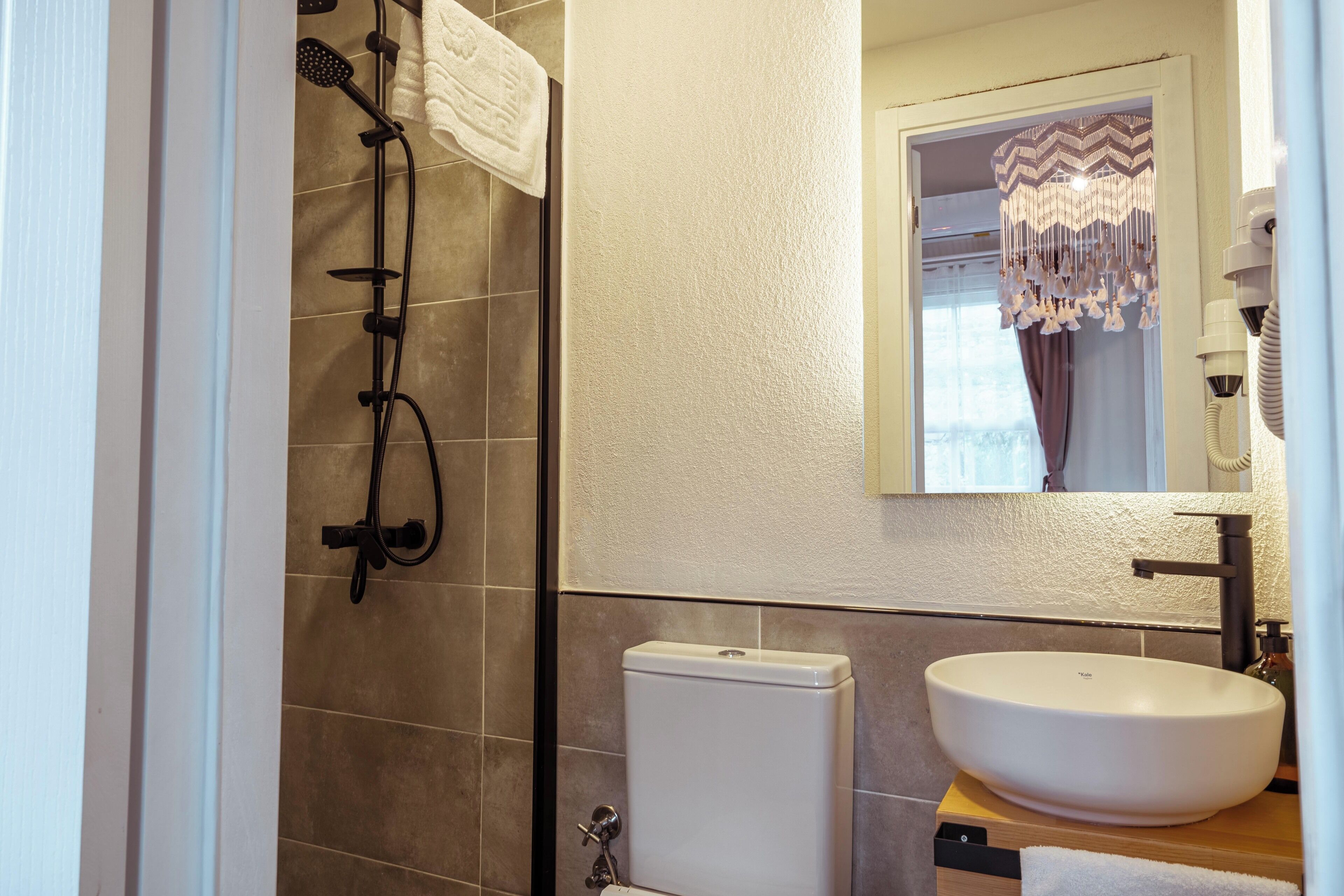 A bathroom with a toilet, sink, and shower.