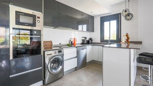 Una cocina moderna con electrodomésticos de acero inoxidable, lavavajillas y lavadora integrada.