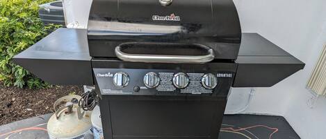 A Char-Broil Advantage portable grill with a gas tank and a control panel, placed on a concrete surface with colorful lines.