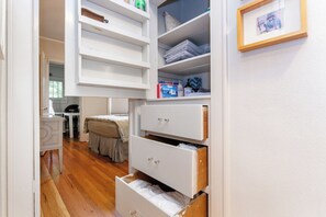 A bedroom with a bed, a desk, and a wardrobe with multiple drawers. - Perfectly Walkable Congress Park Home w/ Office and Fenced-in Shaded Back Yard (Denver)