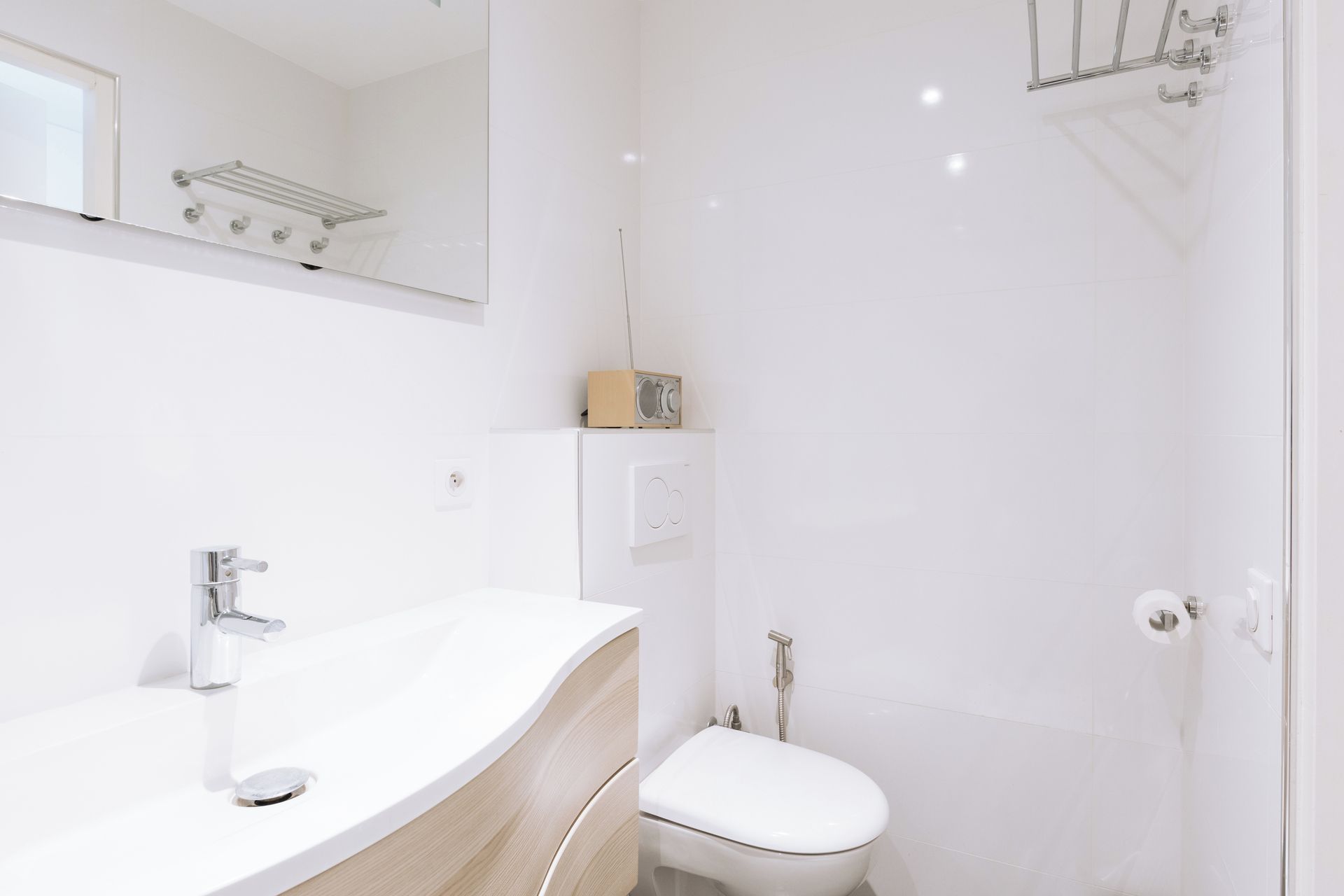 A modern bathroom with a white sink, a toilet, and a shower area.