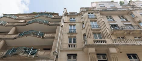 Un edificio de varios pisos con balcones y un estilo arquitectónico clásico.