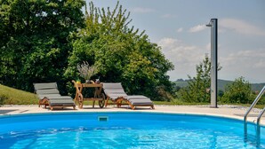 A swimming pool with lounge chairs and a wooden cart with drinks. - Pet friendly home in Veliki Lovrecan with sauna (Veliki Lovrecan)