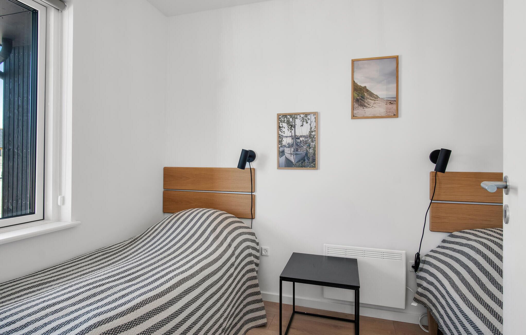 Een kleine, schone kamer met twee eenpersoonsbedden, een tafeltje en een radiator.