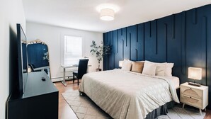 A modern bedroom with a large bed, bedside tables, a desk, and a mirror. - Bright, chic & spacious by Summit/Hamline in St Paul with porch and swing chairs (Saint Paul)