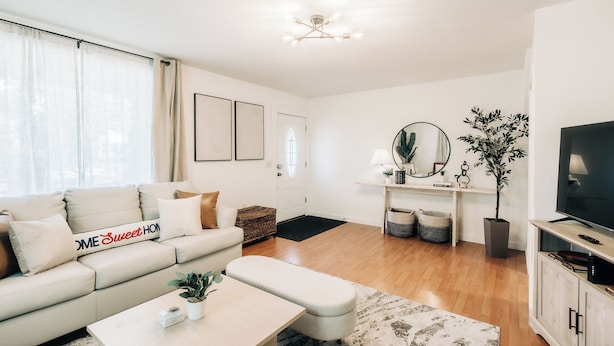 A modern living room with a sofa, coffee table, and television. - Bright, chic & spacious by Summit/Hamline in St Paul with porch and swing chairs (Saint Paul)