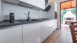 Eine moderne Küche mit weißen Schränken, einer schwarzen Arbeitsplatte und einem eingebauten Herd.