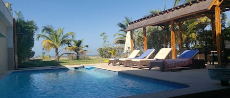 Piscine extérieure, parasols de plage, chaises longues