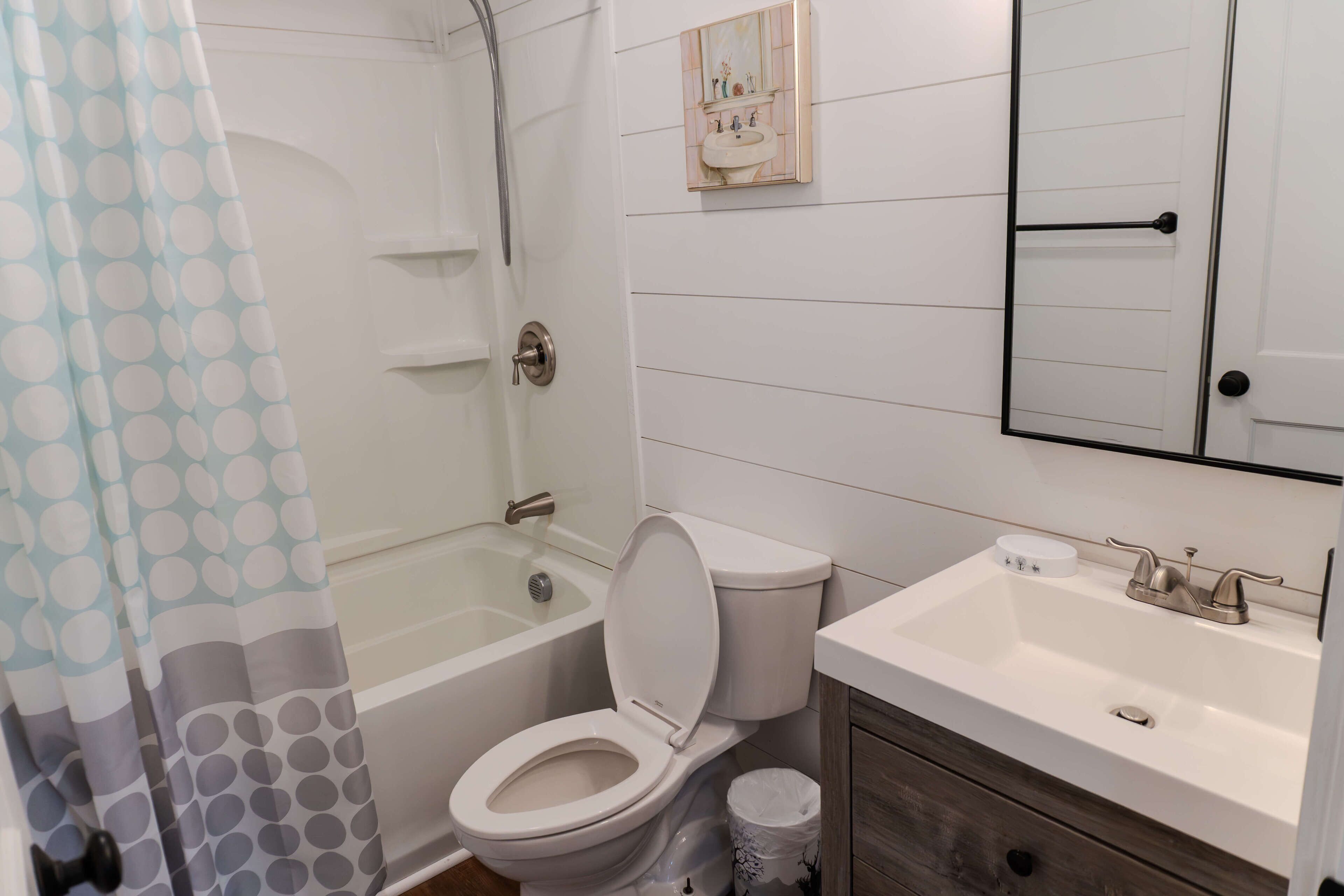 A bathroom with a toilet, sink, and bathtub.
