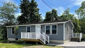A single-story mobile home with a front porch and a small deck. - Deer Ridge A/C, Firepit, Pool Table, Acadia (Ellsworth)