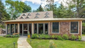 A modern house with a stone pathway leading to the entrance, surrounded by greenery and a clear sky. - Turnstone Cottage @ Acadia NP (Southwest Harbor)