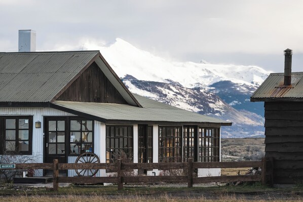 A rustic building with a wooden facade, large windows, and a metal roof. - BORIES - Boutique Guest House (Natales)