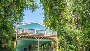 A covered wooden deck with a view of a building.