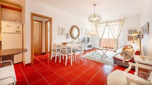 Un espacio habitable compacto con comedor, cocina y dormitorio.