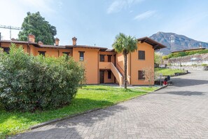 Ein Gebäude mit einer Treppe, die zu einer Tür führt, einer Palme und einem Berg im Hintergrund.