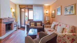 Ein Wohnzimmer mit Kamin, Sofa, Sesseln und einem Tisch.