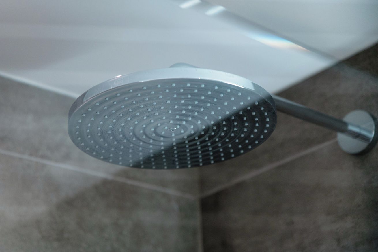A showerhead with a circular design and a metallic finish.