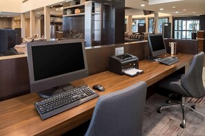 Un espacio de oficina moderno con cubículos, sillas ergonómicas y computadoras de escritorio.