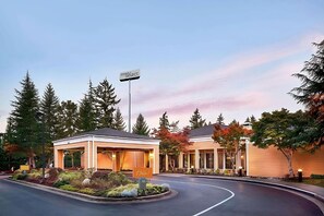 Un hotel de diseño moderno, con un área de estar exterior cubierta y un jardín bien cuidado.