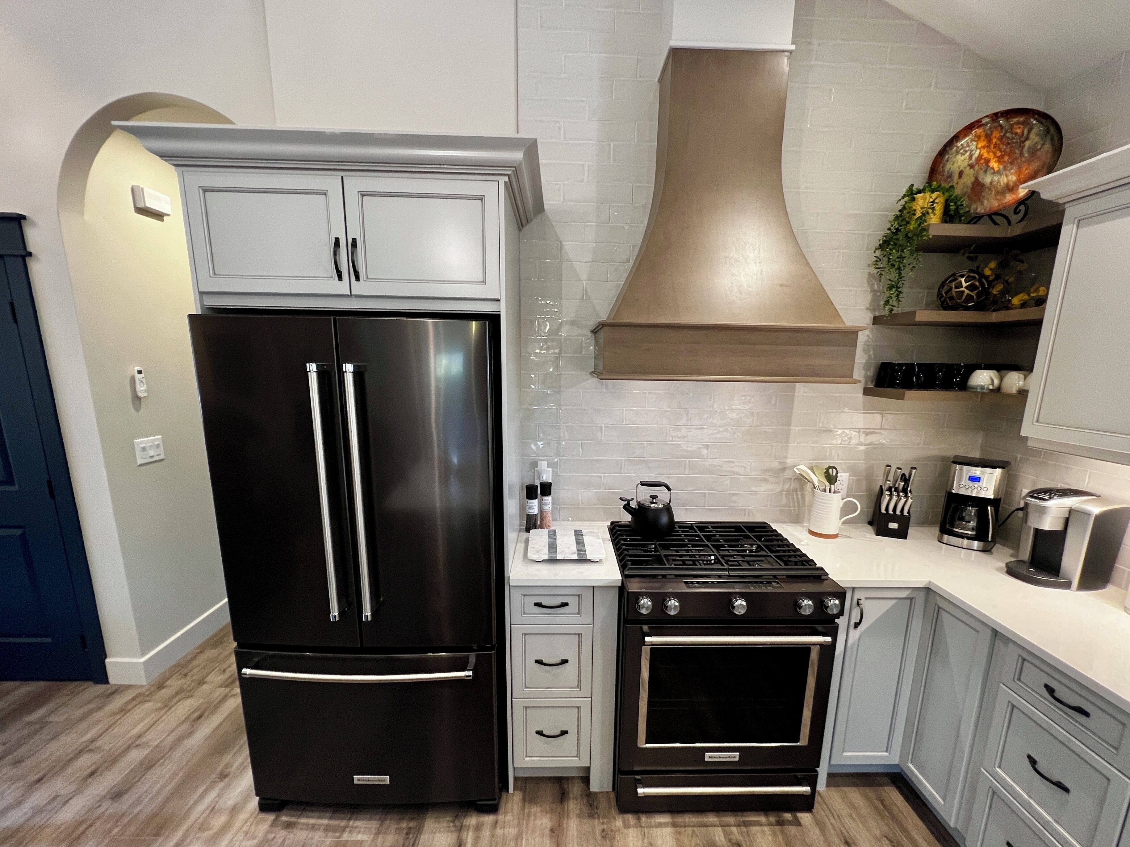 A modern kitchen with a stainless steel refrigerator, a gas stove, and a built-in oven.