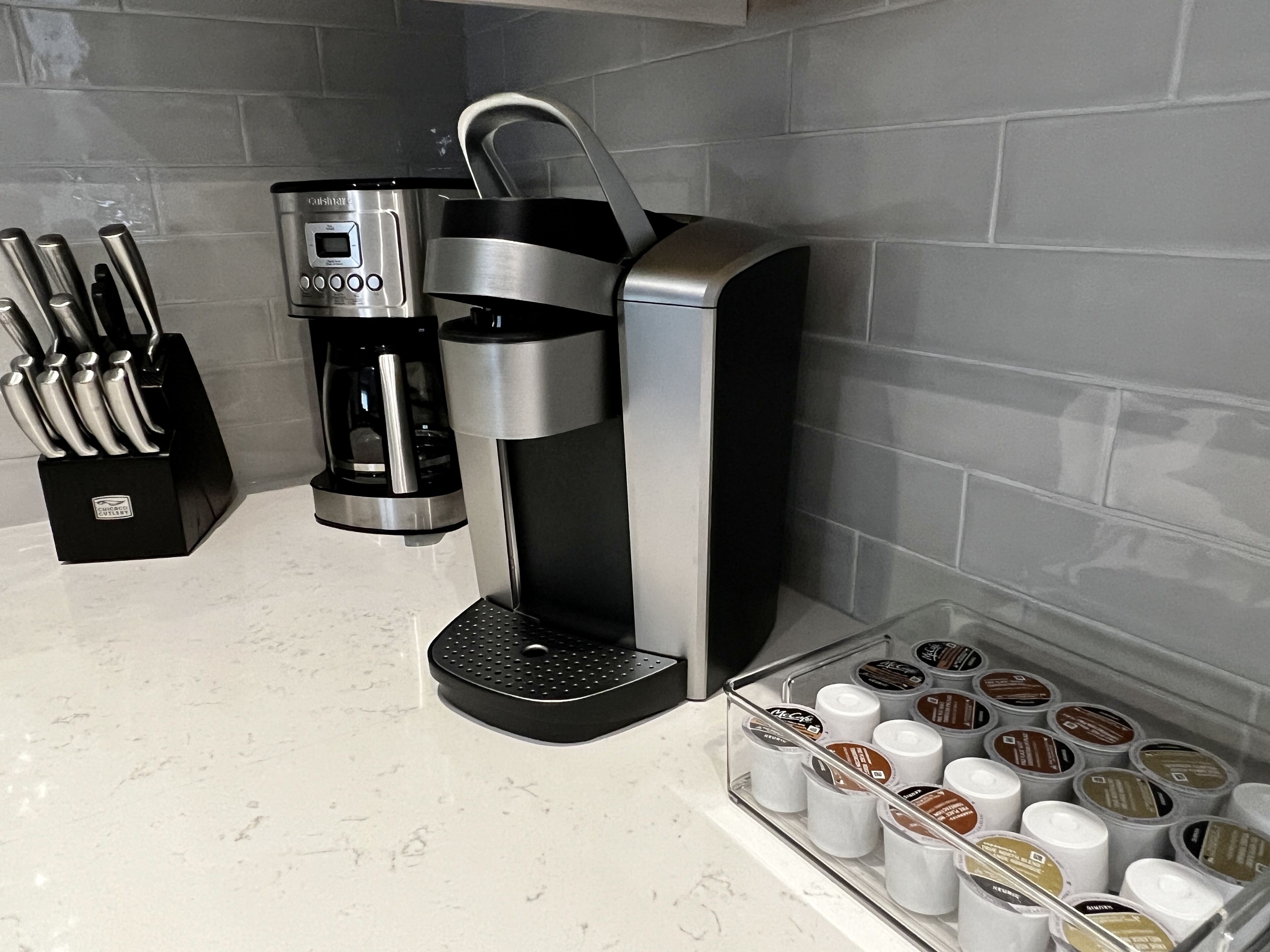 A coffee machine with a drip tray and a coffee pod holder on a countertop.