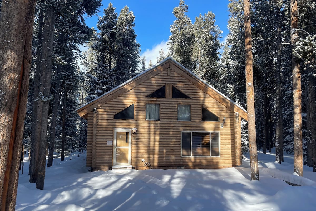 A log cabin surrounded by snow-covered trees.