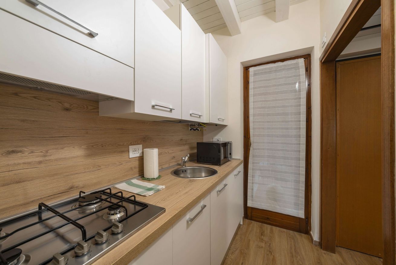 A compact kitchen with a gas stove, a microwave, and a sink.